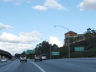 A roadside sign advising of using Exit 24B (Grand Avenue) for Chino Hills is posted. Back in 2005, the elevated carpool lanes were still under construction (including the direct connection from California 57 north to California 60 east); they were done by 2007.
