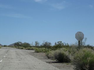 A bleached stop sign marks the intersection where Pinto Road overtakes the abandoned alignment of U.S. 60/70 along Box Canyon Road.