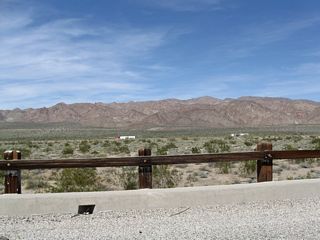 This view looks north through the wooden bridge railing toward the Eagle Mountains.
