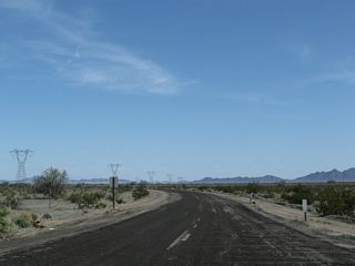 Historic U.S. 60-70 (Chuckwalla Road) turns east toward Hopkins Well and again passes under the 500kV Southern California Edison power lines.