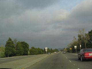 Late-day sun illuminates California 61 as the state route angles southeast away from the San Leandro Channel Drawbridge.