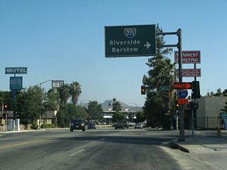 Turning south on H Street, an overhead guide sign points the way to Interstate 215 north to Barstow and south to Riverside.