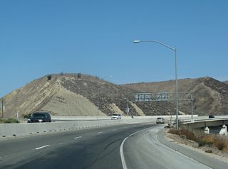 Ramps from a compact trumpet interchange combine as SR 71 north crosses the Santa Ana River north from SR 91 (Riverside Freeway).