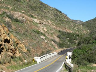 California 74 uses a 1929 deck arch bridge to span San Juan Canyon near the western entrance to Cleveland National Forest. The state route proceeds uphill from here; the initial view looks east, and the subsequent views show the bridge's substructure. Unfortunately, graffiti and vandalism have taken hold, but the bridge remains in use.