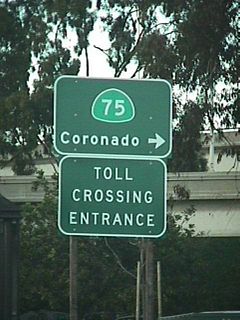 Signage for the toll crossing entrance from Cesar Chavez Parkway (The parkway was known as Crosby Street at the time this picture was taken; Crosby Street was a surface street near the Interstate 5/California 75 interchange near Barrio Logan that was renamed as Cesar Chavez Parkway in April 2002.) to San Diego-Coronado Bay Bridge. This crossing is no longer toll (as of July 2002), so this sign has been removed.