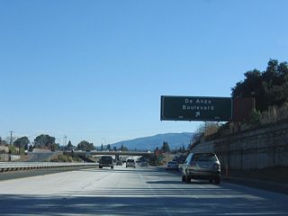 Southbound California 85 (West Valley Freeway) reaches Exit 16, De Anza Boulevard.