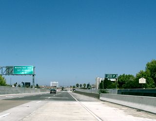 Back on the mainline, northbound California 87 ascends onto an elevated viaduct to carry the freeway through downtown San Jose while remaining above the Guadalupe River, which passes below the freeway. From here one can see the exit to Julian Street on the collector distributor lanes. A mileage sign is posted for San Jose International Airport; the exit is three miles ahead.