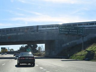 As the CalTrain passes overhead, southbound California 87 approaches the next three exits: Exit 4, Alma Avenue; Exit 3B, Santa Clara County Route G-8 (Almaden Expressway); and Exit 3A, Curtner Avenue.