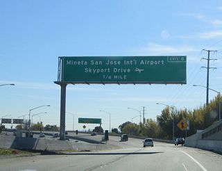 Meanwhile, upon exiting from U.S. 101 (Bayshore Freeway), the first exit on California 87 (Guadalupe Parkway) is Exit 8, Skyport Drive and Airport Parkway to the Norman Y. Mineta International Airport (a portion of this sign can be seen in the previous photobox). The terminals are located closest to this interchange, so this is the best exit from any San Jose freeway to the airport. All of California 87 is located within the city of San Jose, which is home to 894,943 people as of the 2000 Census. Founded on November 29, 1777, and incorporated on March 27, 1850, San Jose is the third largest city in California (behind Los Angeles and San Diego). San Jose consists of 178.2 square miles and sits at an elevation of 85 feet. Rainfall in San Jose is much less than San Francisco due to its location at the south end of the San Francisco Bay and enclosure within mountains. The average annual precipitation is 14.4 inches.