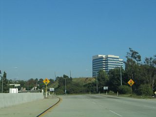 Eastbound California 90 approaches the final exit, which is an intersection with Slauson Avenue that is governed by a traffic signal.