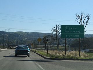 As California 90 crosses over the Santa Ana River, the state route leaves Yorba Linda and enters Anaheim. California 90 next approaches California 91 (Riverside Freeway). Traffic turning west onto the freeway should stay right.