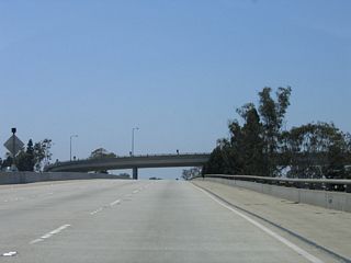 California 90 passes over Interstate 405 (San Diego Freeway) on its elevated viaduct. Interstate 405 stays at or below grade through this interchange. A sweeping ramp passes overhead, carrying traffic from California 90 east to Interstate 405 north.