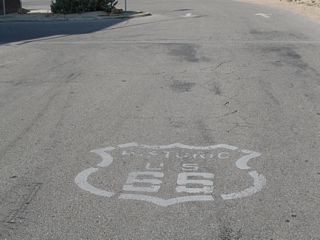 A Historic U.S. 66 marker painted on the parking lot for the historic Barstow railroad depot and Harvey House, which is located in front of the Historic U.S. 66 Museum. The museum is 0.7 miles north of Historic U.S. 66 (Main Street) off old U.S. 91 (N 1st Avenue).