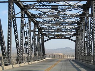 Construction in 2023-24 replaced the Old Iron Bridge with a new alignment and span across the BNSF Rail yard to the west. The original truss bridge was subsequently demolished.