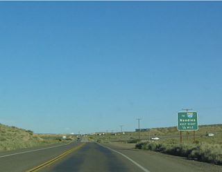 Until the freeway connection along SR 58 was completed south of Barstow, regional travelers were relegated to this two-lane stretch of Old Highway 58 to join Interstate 40 via southbound I-15. Posted during that time period, this guide sign for I-40 remains posted as of May 2025.