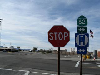 A gas station and a California Agricultural Inspection Station line the corners of the four-way stop sign intersection at U.S. 95/SR 62.