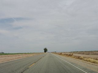 Continuing east, California 98 now enters irrigated fields of verdant acres, with agricultural operations prevalent on both sides of the flat highway.