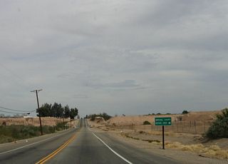 California 98 prepares to dip to its lowest point along the route, as it enters the New River valley. The Imperial County refuse disposal site is located adjacent to the river.
