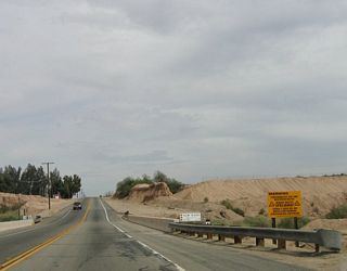 A two-lane bridge carries California 98 over the New River. Often touted as one of the most polluted rivers in the country, the New River carries pollutants from Mexicali, Baja California, Mexico. As it picks up agricultural runoff, the New River swells with chemicals, sewer waste, and other untreated byproducts. This toxic stew empties into the Salton Sea, bringing the toxicity level upward for the fragile, beautiful sea.