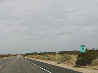 Agriculture, in its most limited forms, becomes noticeable after California 98 crosses under the trio of power lines. Palms are grown in a nursery on the south side of California 98 in the distance.
