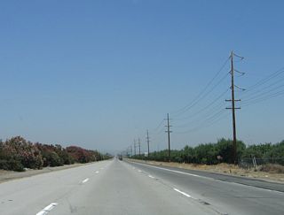 A set of Pacific Gas and Electric power lines will follow the east side of the freeway from here north for several miles. Even though this interchange is located pretty far south, the power lines here are standard issue subtransmission lines for Pacific Gas and Electric, which provides electricity to most locations in the Central Valley. Southern California Edison territory begins at the Grapevine (Interstate 5 ascending from the floor of the Central Valley to Tejon Pass in the Sierra Madre Mountains in Angeles National Forest at an elevation of 4,183 feet) and continues south into Orange County, excluding the area served by the Los Angeles Department of Water and Power.