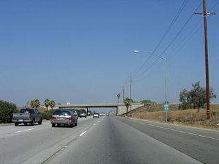 A California 99 confirming marker is posted after the on-ramp from California 166, prior to passing under the California 166 bridge.