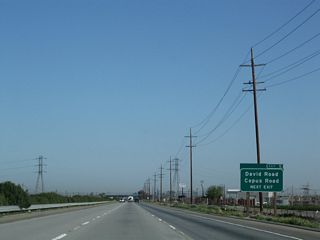 The second advance guide sign for Exit 5, David Road and Copus Road contains the exit number, unlike the first approach sign. David Road heads due east, meeting Wheeler Ridge Road (former California 184) and ending at Rancho Drive near Tejon Creek. Copus Road, meanwhile, heads west, meeting Interstate 5 and then paralleling the California Aqueduct en route to Lakeview and California 33 south of Taft and north of Maricopa.