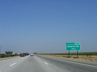 The next exit along northbound is Exit 7, Sandrini Road (one mile). Sandrini Road travels east to connect with Wheeler Ridge Road (former California 184) and Edison Road.