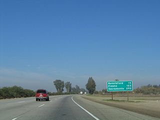 This mileage sign along California 99 north provides the distance to Bakersfield (15 miles), Fresno (123 miles), and Sacramento (293 miles).