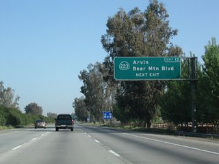 Northbound California 99 (Golden State Highway) approaches Exit 13, California 223 (Bear Mountain Boulevard).