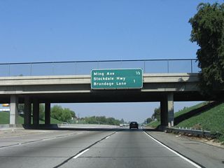 This mileage sign provides the distance to the next two exits along California 99 north: Exit 23, Ming Avenue and Exit 24, California 58 east, Stockdale Highway west, and Brundage Lane.