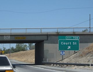 Northbound California 99 meets Exit 70B, Court Street in Pixley. Ahead, California 99 will leave Pixley and reenter rural, agricultural land.
