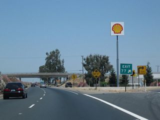 The off-ramp to Exit 77, Avenue 152 (Olive Street) leads to motorist services, including gas.