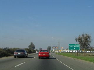 Northbound California 99 meets Exit 90, Oaks Street. This interchange, in conjunction with Exit 91, more or less serves as the northern terminus of the business route through the city of Tulare.