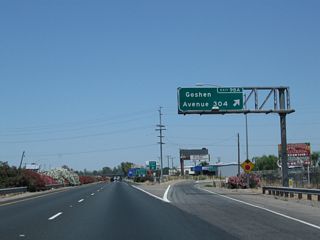 Northbound California 99 (Golden State Highway) meets Exit 98A, Tulare County J-32 (Goshen Avenue) east to Goshen and Visalia. While California 198 provides a freeway connection from California 99 to Visalia, Tulare County J-32 follows a rural road into the seat of Tulare County. This exit serves the community of Goshen (population 3,006 as of 2010 Census), which lies along the east side of California 99.