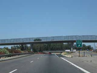 The Betty Drive pedestrian bridge was under construction in 2004 and completed soon afterward. The gore point is located near the pedestrian bridge before the freeway drops below grade to pass under Betty Drive itself.