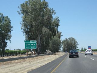 California 99 continues to follow the railroad as it passes through northern Tulare County. This picture shows a relatively new sign placed for Tulare County J-38 (Dodge Avenue). CR J-38 is an east-west county route that begins at Exit 109 and proceeds east to end at California 63 and California 201 in Calgro.