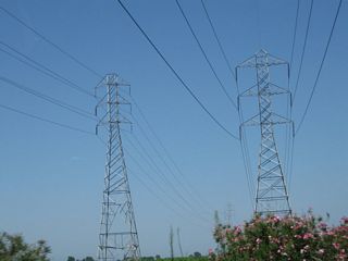 A pair of Pacific Gas and Electric power lines pass over California 99 around the same point as the previous picture. The larger of these two lines is a 230kV line that travels due west to link with the major power line corridor that parallels Interstate 5 north of Coalinga. Both lines lead northeast from here into a substation located to the west of Leonard Avenue and north of Manning Avenue just a short distance away from the freeway.