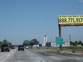 As noted above, use Manning Avenue west to Bowles, Raisin City, San Joaquin, and Interstate 5 Exit 365. To the east, Manning Avenue passes through Parlier and Reedley before ending at California 63. Access to Orange Cove is afforded via CR J-19 (Hills Valley Road) north. This was the first exit number sign to be posted for Exit 121 along northbound before the overhead signs were posted. Note that this section of California 99 north was widened to three lanes before the section south of California 43.