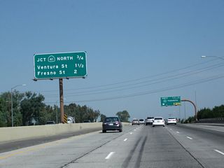 This mileage sign along California 99 north provides the distance to the next three exits: Exit 131, California 41 (Yosemite Freeway) north; Exit 132A, Ventura Street (Former California 180 east) to Kings Canyon Road; and Exit 132B, Fresno Street (Former California 180 west).