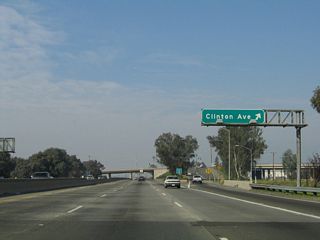 Northbound California 99 (Golden State Highway) meets Exit 136, Clinton Avenue. At this point, traffic from Golden State Boulevard (Old U.S. 99) merges onto California 99 north. Golden State Boulevard used to be a through route, but the segment from the Belmont Avenue traffic circle south to California 180 was demolished and is now longer passable. The rest of the G Street segment is still passable.