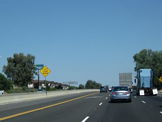 The left lane of California 99 north temporarily ends after the Ashlan Avenue interchange. This segment of freeway is being upgraded to three northbound lanes.