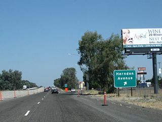 Northbound California 99 reaches Exit 143, Herndon Avenue. Between this interchange and the San Joaquin River bridge, a final on-ramp (not shown) brings traffic from Golden State Boulevard (Former California 99 Business / Motel Drive) onto California 99 north.