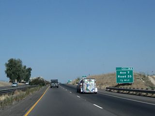 The first exit along California 99 (Golden State Highway) in Madera County is Exit 144, Avenue 7 and Road 33. This sign is posted after the San Joaquin River bridge.