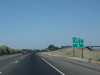 Northbound California 99 meets Exit 144, Avenue 7 and Road 33. Like Tulare County and Yolo County, Madera County uses a grid system to number its county-maintained routes. Avenues run east-west and roads run north-south, and numbers represent one-mile increments from the southernmost or westernmost point within the county limits.