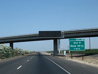 The next exit along California 99 (Golden State Highway) is Exit 147, Avenue 9 and Road 30 1/2 (one mile). This exit number sign was posted by 2004.