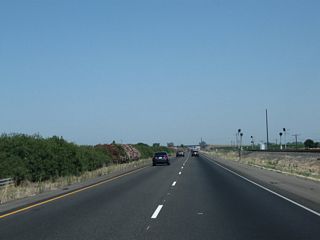After the Avenue 9 interchange, the northbound lanes of California 99 run close to the edge of the railroad tracks.