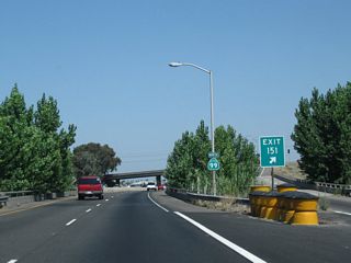 A California 99 north reassurance shield is posted immediately after the gore point for Exit 151.