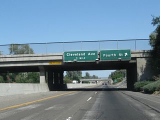 Northbound California 99 reaches Exit 154, Fourth Street in Madera. This sign is mounted onto Yosemite Avenue. Access to Fourth Street is limited to northbound motorists; there is no access from southbound California 99 as this interchange is a half-diamond. A return to California 99 north is provided by following H Street (frontage road) north. The next exit is Exit 155, Cleveland Avenue.