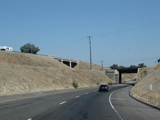 Northbound California 99 descends below grade and approaches a railroad overcrossing prior to reaching Exit 167. The sight distance through here is reduced as compared to the freeway segments south of here.